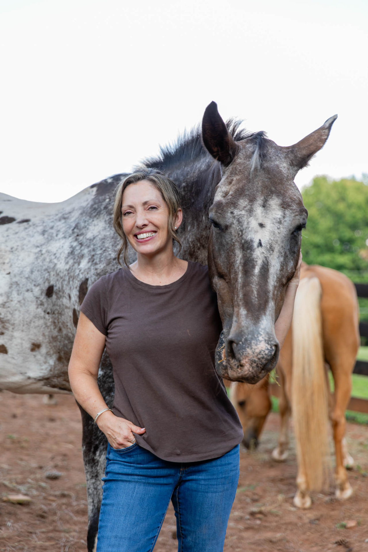 Jennifer Kozel standing beside a horse